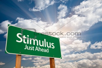 Stimulus Green Road Sign with Dramatic Clouds, Sun Rays and Sky.