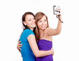 two young women taking pictures with digital camera - isolated on white