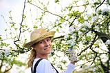 Young woman gardening - in apple tree orchard