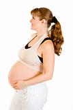 Smiling beautiful pregnant woman holding her belly isolated on white
