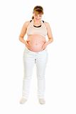Beautiful pregnant woman holding her belly isolated on white

