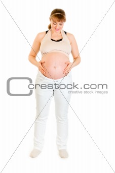 Beautiful pregnant woman holding her belly isolated on white
