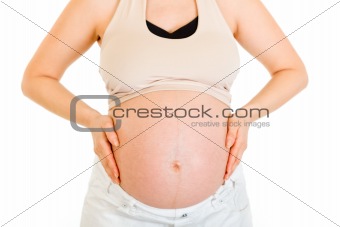 Pregnant woman holding her belly. Close-up.
