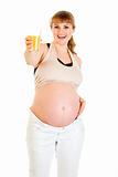 Happy pregnant woman holding glass of juice in hand
