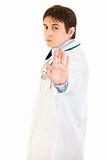 Authoritative medical doctor showing stop gesture
