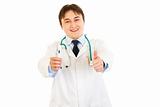 Smiling  doctor holding medical thermometer and showing thumbs up gesture
