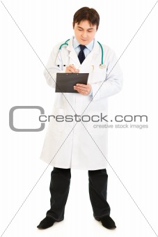 Serious doctor  with stethoscope making notes in medical chart
