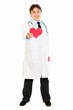 Smiling medical doctor holding paper heart in hand
