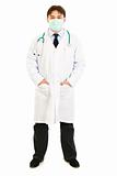 Medical doctor with  mask on face and hands in pockets
