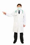 Medical doctor in mask pointing  finger at something
