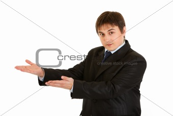 Smiling   businessman presenting something on empty hands
