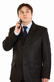 Concentrated businessman holding mobile at head
