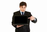 Modern businessman pointing finger on laptops blank screen
