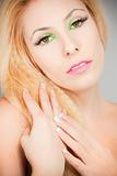 Beautiful blond girl with cat eyes make-up in green