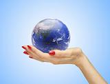 Hand with the world (globe) over blue background