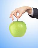 woman hand with fresh green apple over blue