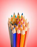 stack of colored pencils over red background