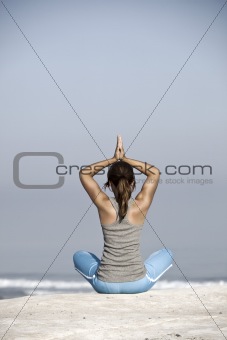 Beautiful young woman with arms open, relaxing on the beach