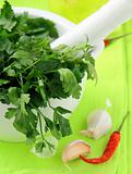 green parsley in a mortar with garlic and pepper
