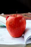 red ripe apple with English textbooks