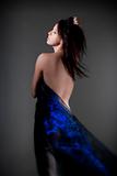 beautiful nude woman with dark hair in blue cloth - isolated on gray