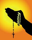 silhouette of hands with a rosary 