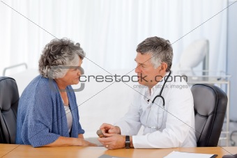 A senior doctor with his patient in his office
