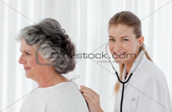 Pretty nurse taking the heartbeat of her patient