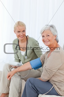 Lovely doctor taking the blood pressure of her patient