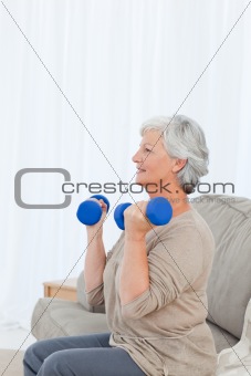 Senior doing her exercises on her sofa