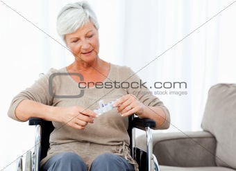 Senior in wheelchair with pills