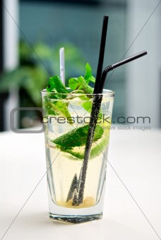Glass of mojito cocktail with a background of interior cafe
