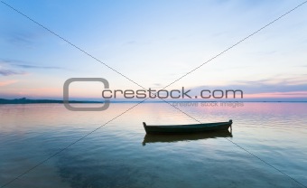 sunset and boat on summer lake bank