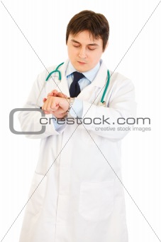 Concentrated medical doctor looking at  clock
