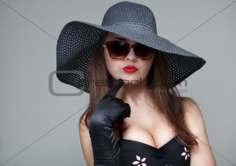 Young woman in black hat and sunglasses 