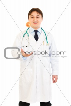 Smiling medical doctor throwing up apple
