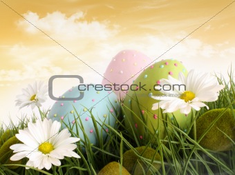 Closeup of decorated easter eggs in the grass with flowers