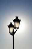 double lamppost against the sun