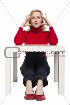 Young woman sitting at funny small desk