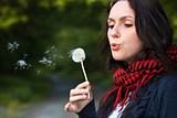 Girl blowing on  dandelion