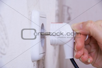 Female Hand Sticks A Plug In The Socket