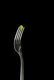 Fresh green peas on a silver fork