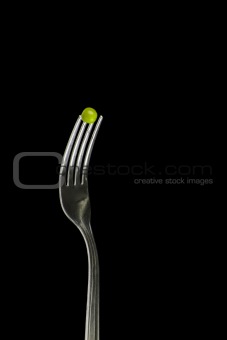 Fresh green peas on a silver fork