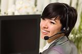 Attractive Young Woman Smiles Wearing Headset Near Her Computer Monitor.