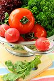 fresh vegetables, cucumber, radish, tomato and lettuce in a colander