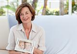 Mature woman showing her picture of her grandchild