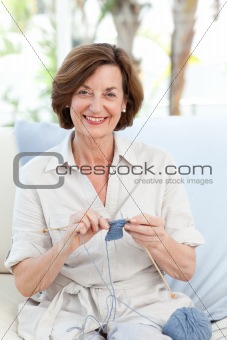 Retired woman knitting at home
