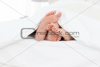 Couple's feet in the bed