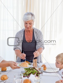 Grandmother serving her grandchildren