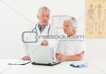 Doctor and his patient looking at the laptop